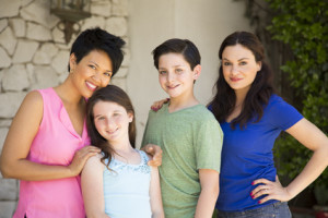 Family with same sex parents standing on porch